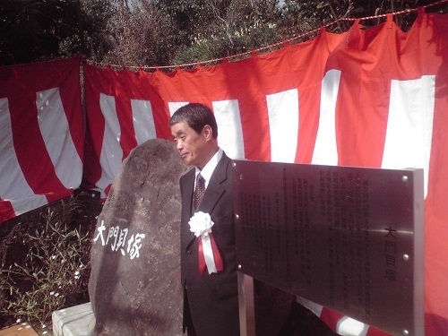 大門貝塚記念碑の側に立つ会員の曽我部氏