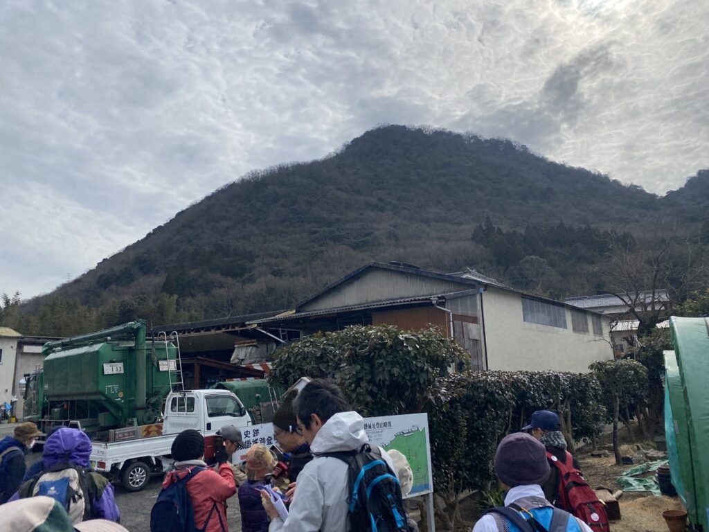 まずは、猿掛城へと向かいます。登山口の説明板の前で、佐藤氏から説明あの山の頂上まで登ります。